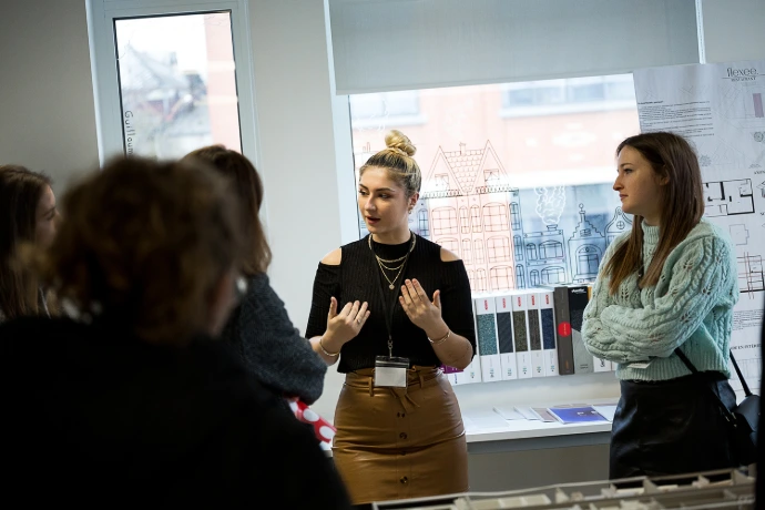 Student presenting her interior design project to a panel of industry partners