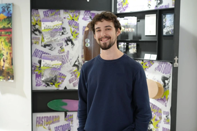 Étudiant en design graphique posant devant son projet d'identité visuelle pour la marque Fastboard