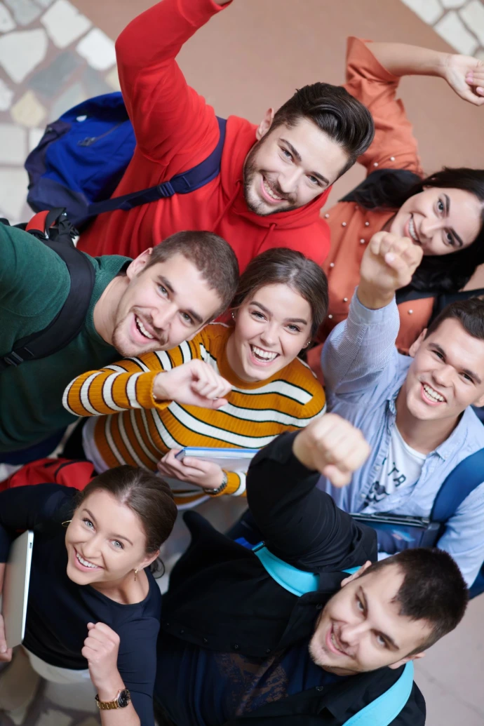 Groupe d'étudiants enthousiastes levant les poings en signe de réussite