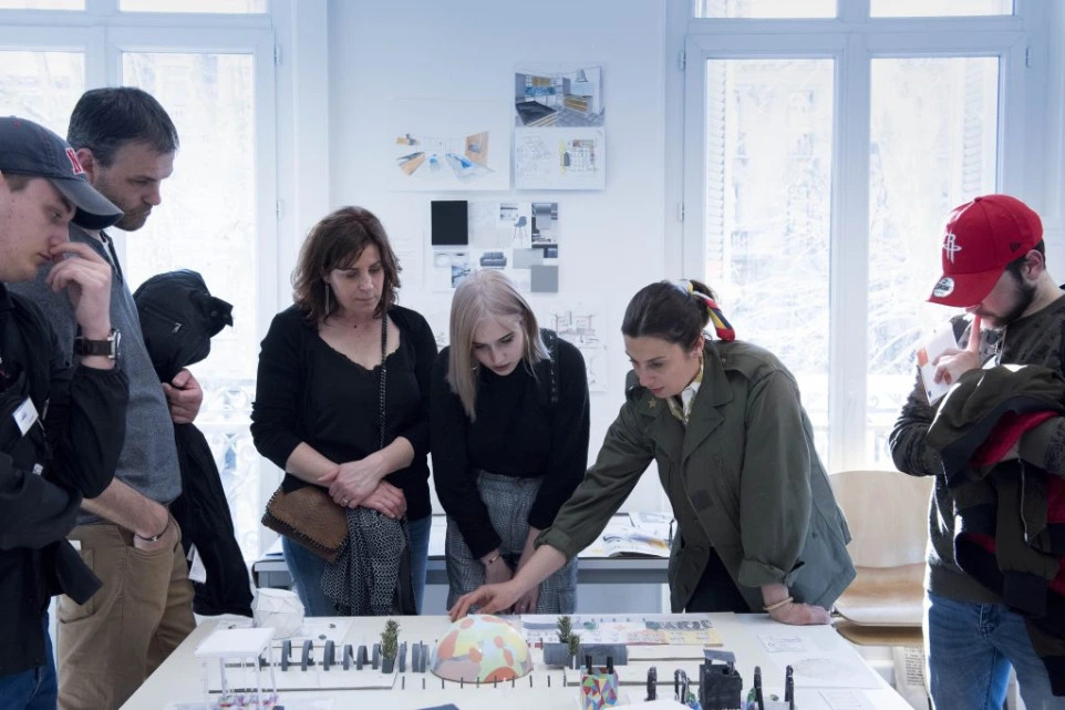 Étudiants et enseignante examinant une maquette d'aménagement urbain colorée au campus ESDAC Strasbourg