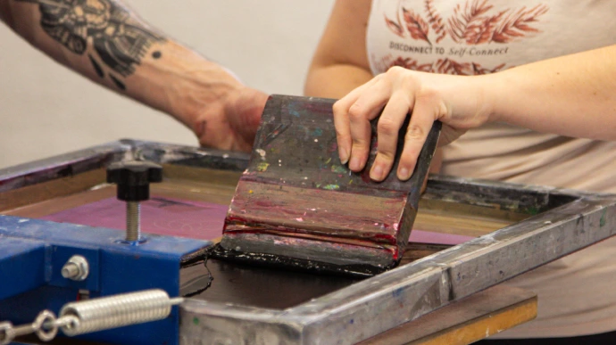 Étudiant réalisant une impression en sérigraphie lors d'un workshop